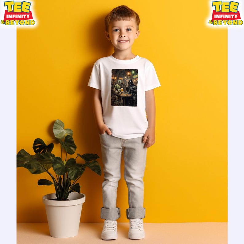 K&ouml;nnte beinhalten: Ein Kind tr&auml;gt ein wei&szlig;es T-Shirt mit einem farbenfrohen Grafikdruck. Der Druck zeigt eine Szene mit Figuren in einer schwach beleuchteten Umgebung. Das Kind tr&auml;gt eine graue Hose und wei&szlig;e Turnschuhe. Der Hintergrund ist leuchtend gelb.