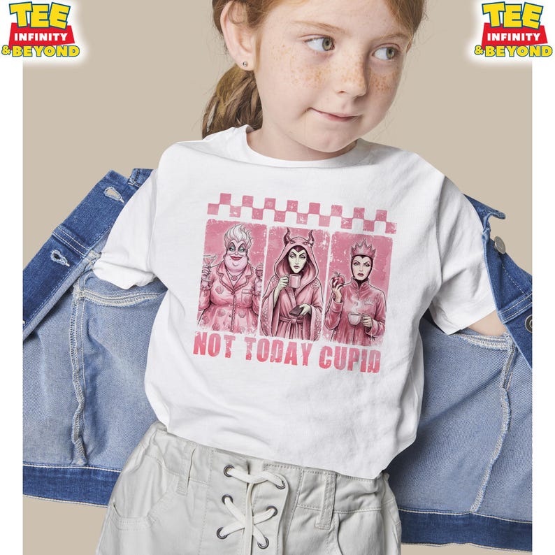 May include: White t-shirt featuring a pink graphic with three cartoon villains and the text "NOT TODAY CUPID". The shirt has a crew neck and short sleeves. The shirt is being worn by a person.