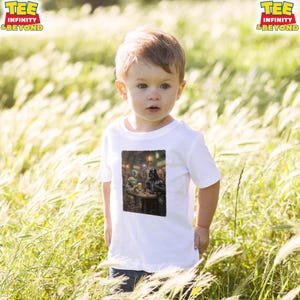 K&ouml;nnte beinhalten: Ein wei&szlig;es T-Shirt mit einem Aufdruck von Darth Vader und Yoda in einer Barszene. Das T-Shirt wird von einem kleinen Kind in einem Feld mit hohem Gras getragen. Das Logo "TEE INFINITY & BEYOND" ist oben links zu sehen.