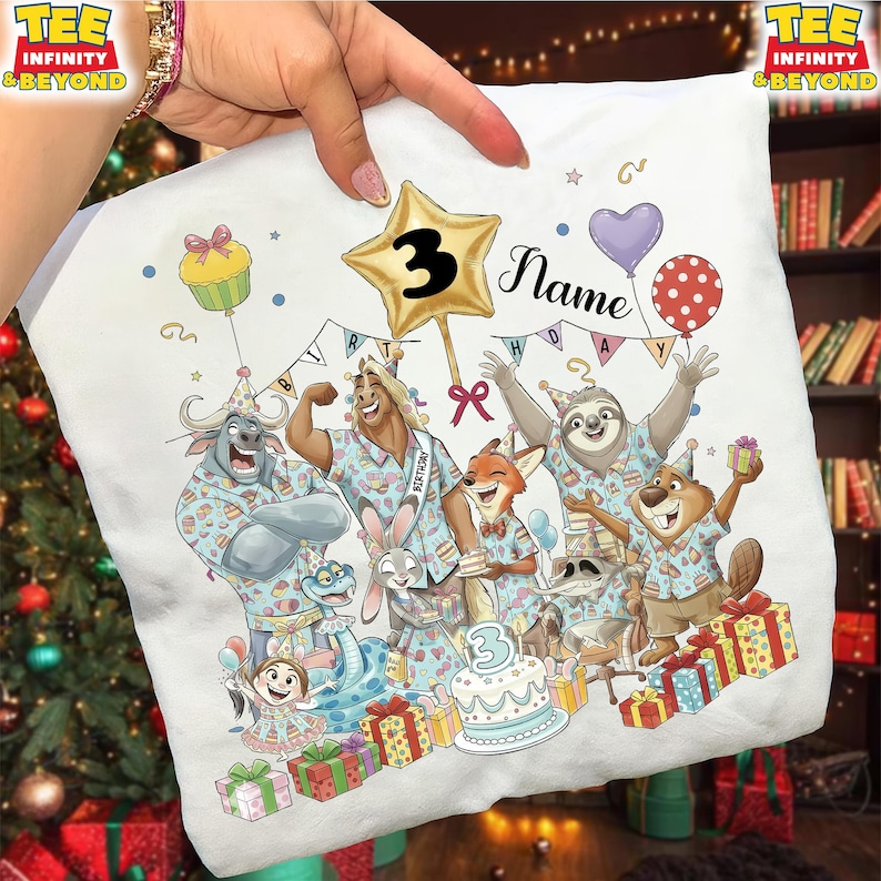 Puede incluir: Camiseta blanca con una ilustraci&oacute;n de dibujos animados de animales celebrando un cumplea&ntilde;os. El dise&ntilde;o incluye un globo de estrella dorada con el n&uacute;mero 3, una tarta y la palabra "Name". La camiseta est&aacute; decorada con globos y cajas de regalo.