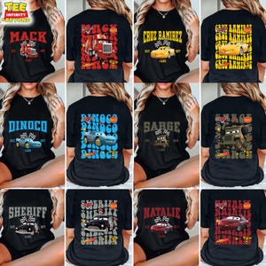 K&ouml;nnte beinhalten: Neun schwarze T-Shirts mit verschiedenen Cars-Charakteren und Namen bedruckt. Die Charaktere sind Mack, Dinoco, Cruz Ramirez, Sarge, Sheriff und Natalie. Die Namen sind in einer Retro-Schriftart gedruckt.