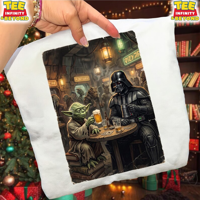 K&ouml;nnte beinhalten: Wei&szlig;es T-Shirt mit einer Star Wars-Illustration. Yoda und Darth Vader sitzen in einer Bar an einem Tisch und halten jeweils ein Bier. Der Hintergrund zeigt eine &uuml;berf&uuml;llte Barszene mit verschiedenen au&szlig;erirdischen Charakteren.