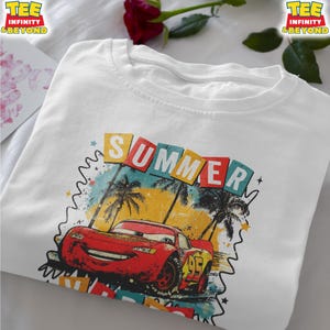 May include: White t-shirt featuring a graphic of Lightning McQueen from the movie Cars, with the word "SUMMER" above the car. The design includes palm trees and a colorful background. The shirt has the text "TEE INFINITY & BEYOND" on the top left and right.