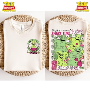 May include: Two off-white t-shirts with graphic designs. One features Oogie Boogie with text "Well, well, well, what have we here?" The other shirt displays Oogie Boogie characters with text "Dogie's Too Frightening Snake Eyes Casino".