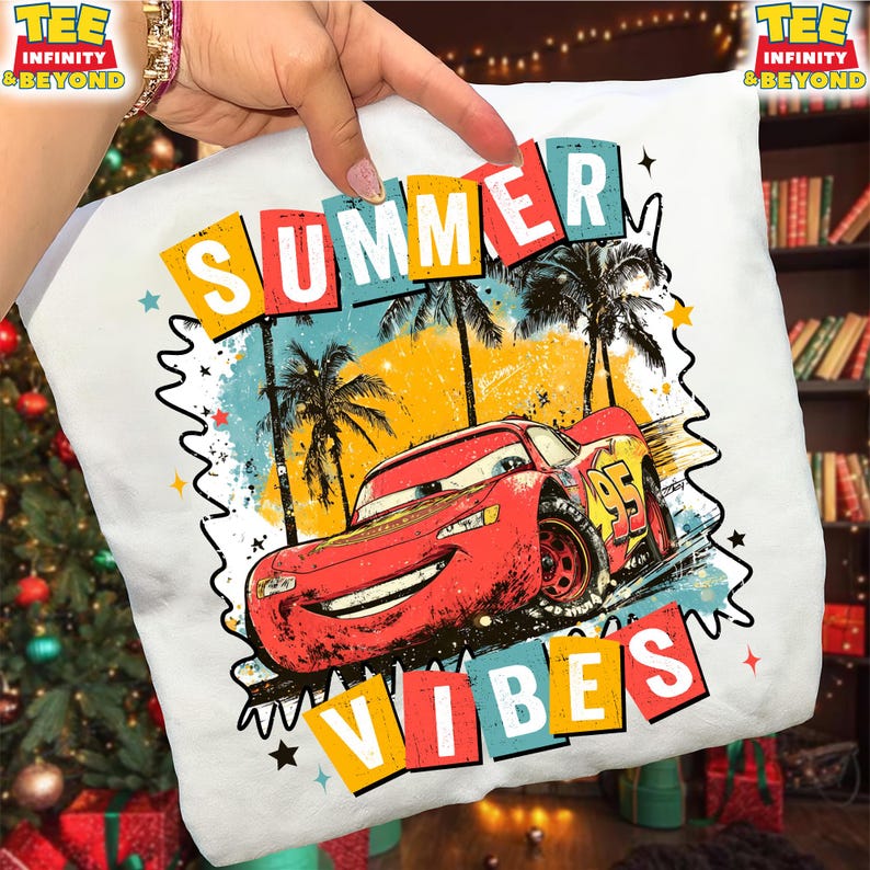 May include: White t-shirt featuring a graphic of Lightning McQueen from the Cars movie. The design includes palm trees, the words "SUMMER VIBES," and the number 95. The design has a retro, colorful style.
