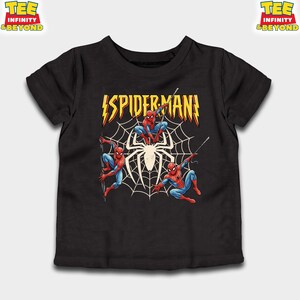 May include: Black t-shirt featuring a graphic of Spider-Man in action poses. The design includes the word "SPIDERMAN" in yellow and red, with a spider web and a large spider in the center. The shirt has short sleeves.