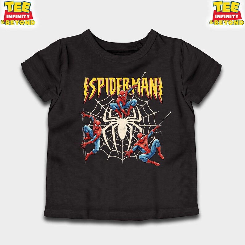 May include: Black t-shirt featuring a graphic of Spider-Man in action poses. The design includes the word "SPIDERMAN" in yellow and red, with a spider web and a large spider in the center. The shirt has short sleeves.