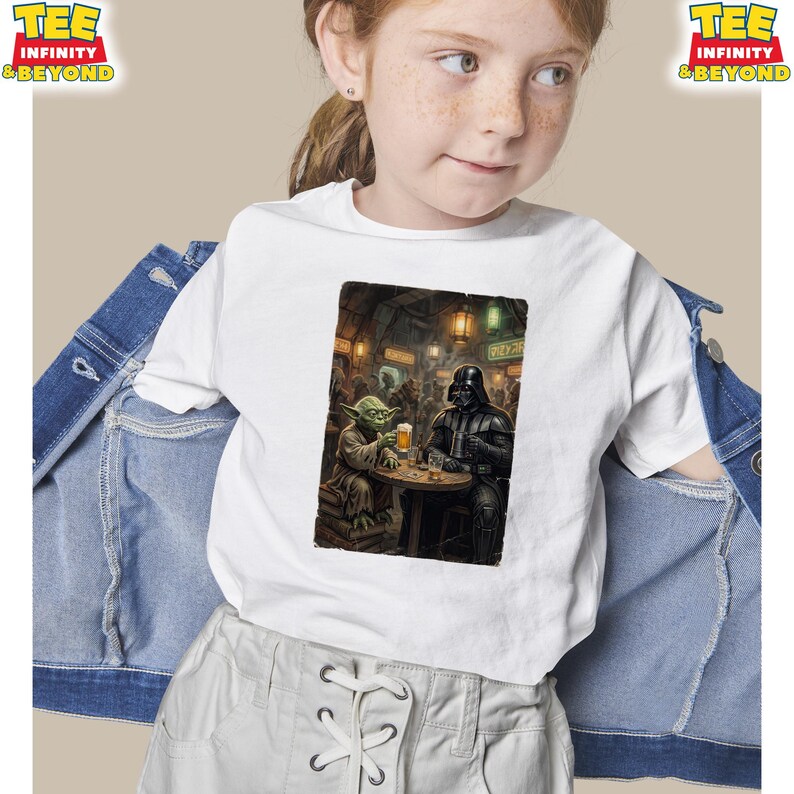 K&ouml;nnte beinhalten: Wei&szlig;es T-Shirt mit einem Star Wars-Motiv. Das Bild zeigt Yoda und Darth Vader in einer Bar, die Bier trinken. Das T-Shirt hat oben den Text "TEE INFINITY & BEYOND". Das T-Shirt wird von einer Person getragen.