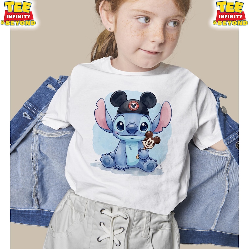 K&ouml;nnte beinhalten: Wei&szlig;es T-Shirt mit einer Cartoon-Illustration von Stitch, der einen Mickey-Mouse-Hut tr&auml;gt und ein Mickey-Mouse-Eis h&auml;lt. Das Shirt hat den Text "TEE INFINITY & BEYOND" oben links und rechts.