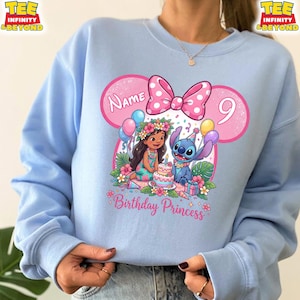 May include: Light blue sweatshirt featuring a pink Minnie Mouse-inspired design with a polka dot bow. The graphic includes the text "Name" and the number "9", along with illustrations of Lilo and Stitch celebrating a birthday. The words "Birthday Princess" are also included.