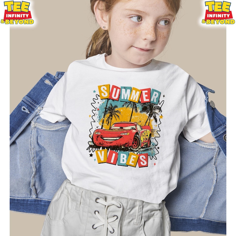 May include: White t-shirt featuring a graphic of a red race car with the text "SUMMER VIBES". The design includes palm trees and a colorful background. The shirt is part of the "TEE INFINITY & BEYOND" collection.