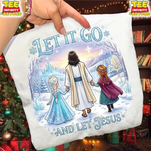 以下が含まれることがあります： イエス、2人の女の子、そして「LET IT GO AND LET JESUS」というテキストが描かれた冬のシーンが特徴の白いTシャツ。デザインには城、山、雪の結晶が含まれています。Tシャツは手で持たれています。