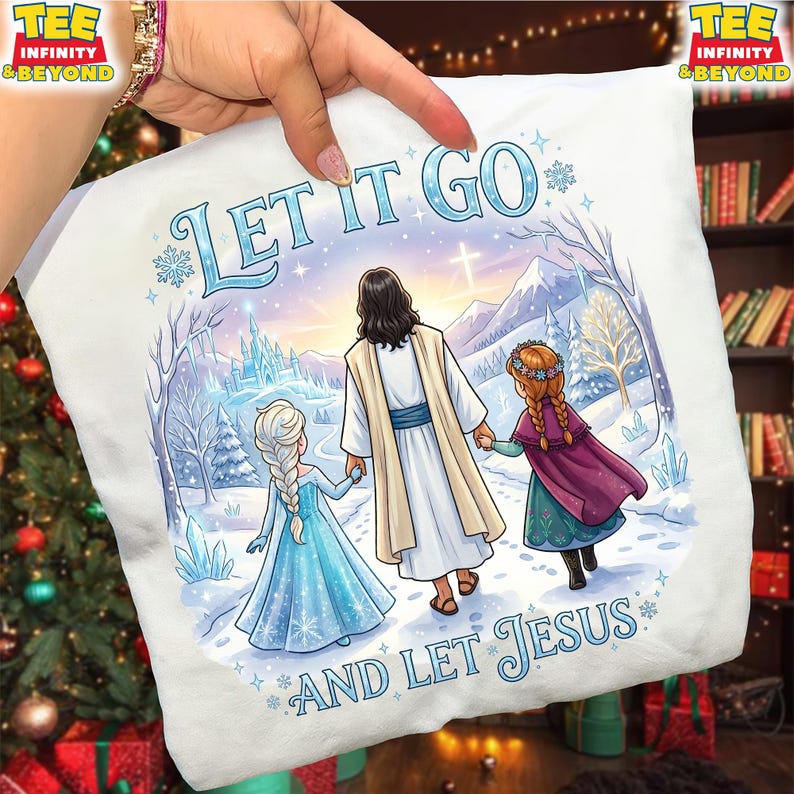 以下が含まれることがあります： イエス、2人の女の子、そして「LET IT GO AND LET JESUS」というテキストが描かれた冬のシーンが特徴の白いTシャツ。デザインには城、山、雪の結晶が含まれています。Tシャツは手で持たれています。