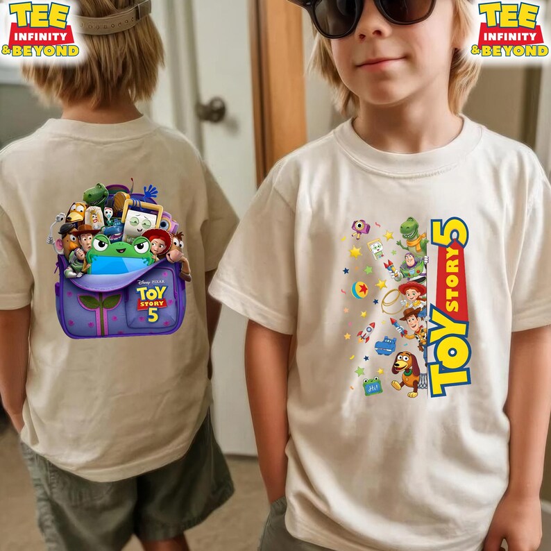 May include: A cream-coloured t-shirt featuring Toy Story 5 graphics. The front displays various characters and the Toy Story 5 logo in blue and yellow. The back shows a purple backpack overflowing with animated characters and the Toy Story 5 logo.