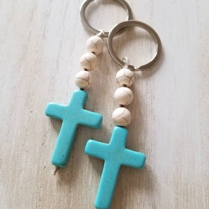 May include: Two turquoise cross keychains with white beads and silver key rings.