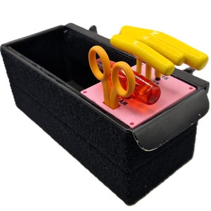 May include: A black storage box with a pink insert and a yellow, orange, and red tool set. The tools include a pair of scissors, a screwdriver, and a set of screwdrivers.