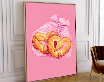 Puede incluir: Impresión enmarcada que presenta dos pretzels blandos en una bolsa de plástico transparente atada con un lazo rosa. Los pretzels son de color marrón dorado con sal. El fondo es de color rosa liso.