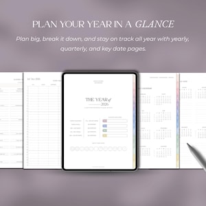 May include: A digital planner with the text "PLAN YOUR YEAR IN A GLANCE". The planner includes yearly, quarterly, and key date pages. The central page displays "THE YEAR of 2026" with a calendar and progress bars. A stylus rests on the right side.