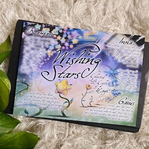 May include: A watercolor illustration of a celestial scene with stars, flowers, and text. The text reads "Wishing Stars", "The Celestial Life Cycle of Magic", "Kamari", "Ina", "Gaius", and descriptions of each element.