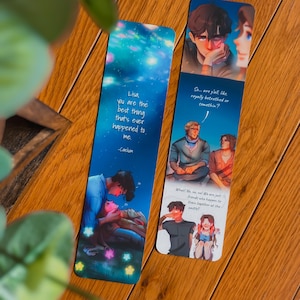 May include: Two illustrated bookmarks with romantic themes. One bookmark features a couple under a starry sky with the text "Lisa, you are the best thing that's ever happened to me." The other shows a couple with the text "So... are y'all like royally betrothed or somethin?"