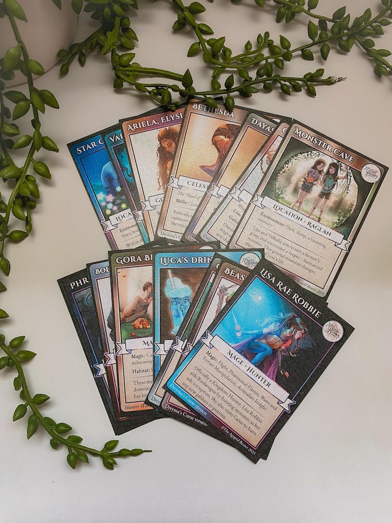 May include: A collection of fantasy-themed trading cards, featuring illustrations of characters and locations. The cards have a black border and include text describing each card's attributes. The cards are fanned out on a white surface.