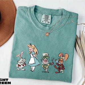 a t - shirt with a picture of alice and the seven dwarfs on it