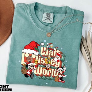 A turquoise t-shirt with a graphic design featuring characters from Disney's "Walt Disney World" and the text "Walt Disney World" printed on it.