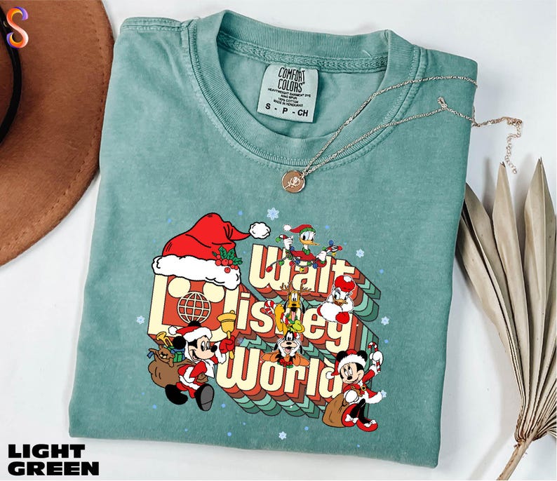 A turquoise t-shirt with a graphic design featuring characters from Disney's "Walt Disney World" and the text "Walt Disney World" printed on it.