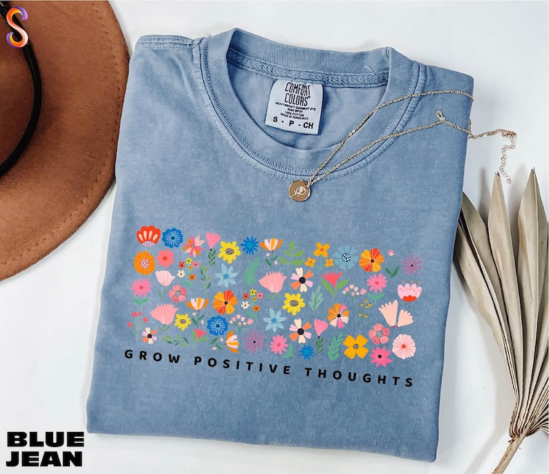 a blue t - shirt that says grow positive thoughts