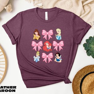 a women's t - shirt with disney princesses on it