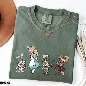 a t - shirt with a picture of alice and the seven dwarfs on it