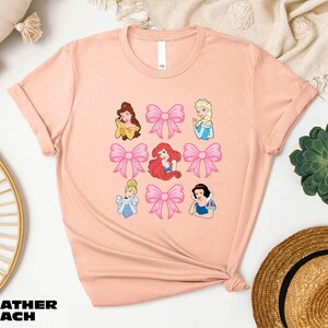 a pink t - shirt with princesses on it
