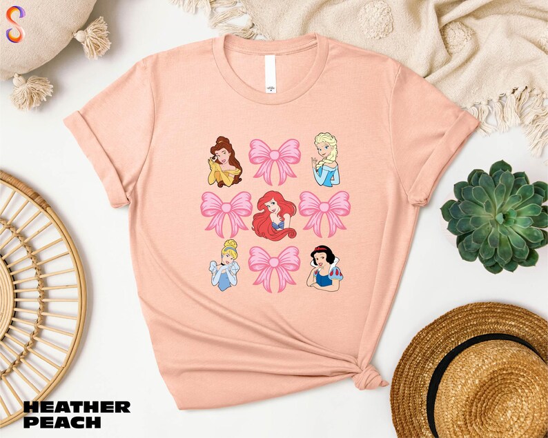a pink t - shirt with princesses on it
