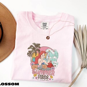 a pink shirt with a picture of a mermaid on it