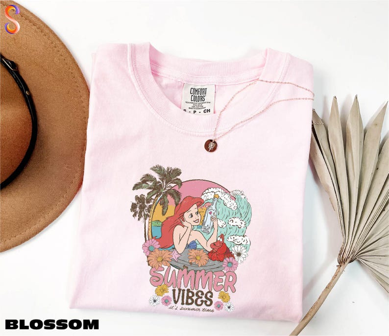 a pink shirt with a picture of a mermaid on it