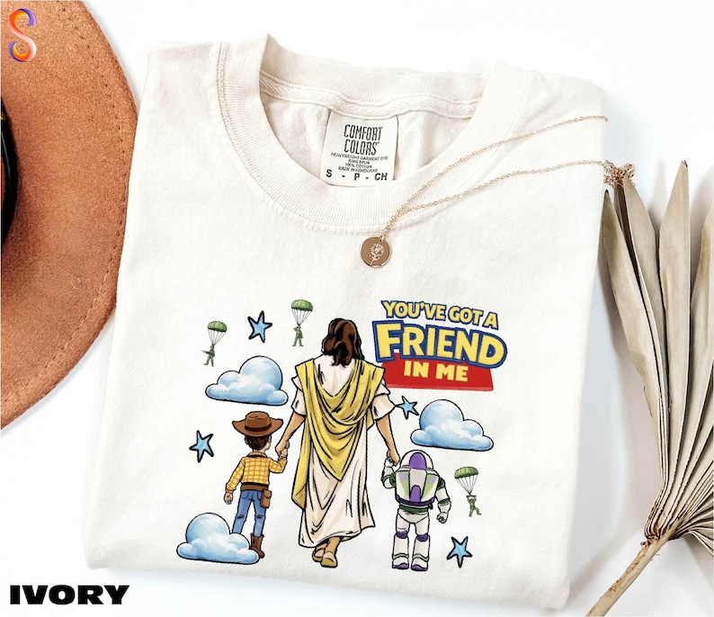 a white t-shirt with a cartoon illustration of a person holding hands with two children, one of whom is a character from the Toy Story franchise. The text on the t-shirt reads "You've got a Friend in Me".