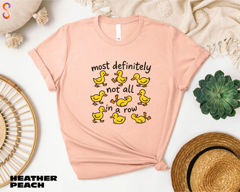a pink t-shirt with a humorous text design, a straw hat, a woven basket, and a potted plant.