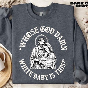 Op de afbeelding: Donkergrijze heather sweatshirt met een witte afbeelding van een religieuze familie en de tekst "WHOSE GOD DAMN WHITE BABY IS THIS?" De sweatshirt heeft lange mouwen en een ronde hals. De tekst "DARK GREY HEATHER" staat rechtsboven.