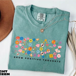 a t - shirt that says grow positive thoughts on it