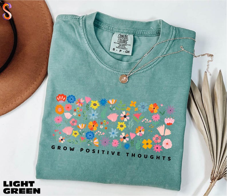 a t - shirt that says grow positive thoughts on it