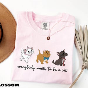 a pink shirt with three dogs on it