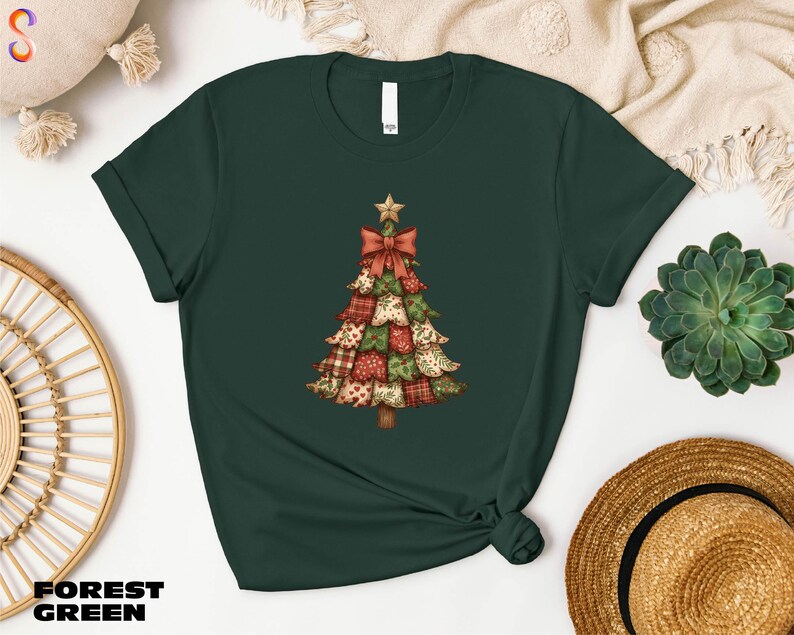 A green t-shirt with a Christmas tree design printed on it, along with other items such as a hat, a woven basket, and a potted plant.