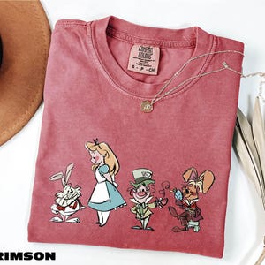 a t - shirt with a picture of alice and the seven dwarfs on it