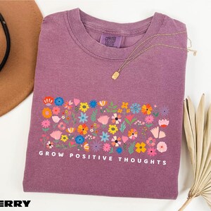 a t - shirt that says grow positive thoughts on it