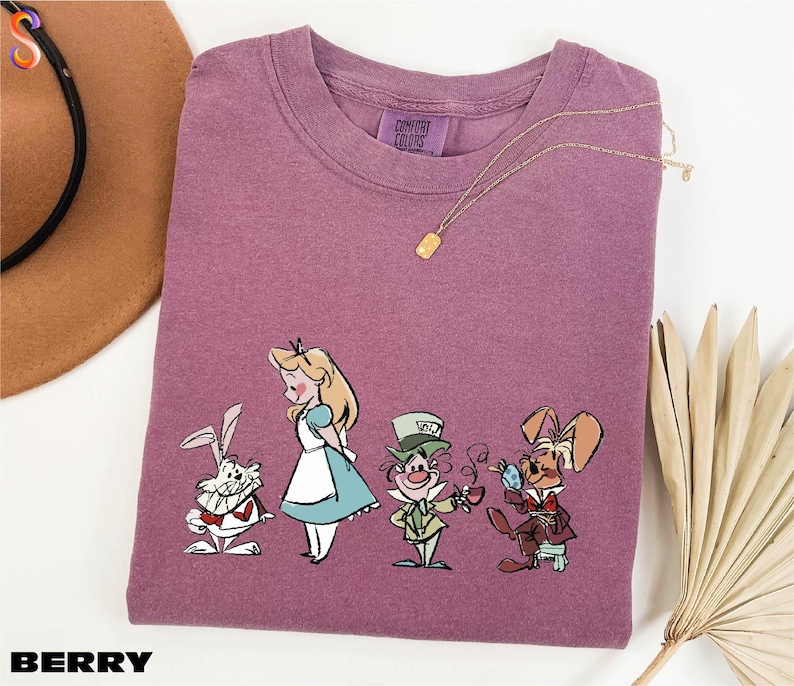 a purple t - shirt with a picture of alice and the rabbit on it
