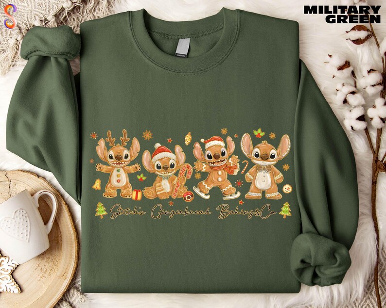 A green sweatshirt with a graphic design featuring four cartoon characters, likely from a children's television show or movie, along with various holiday-themed elements such as snowflakes, Christmas trees, and gingerbread cookies.