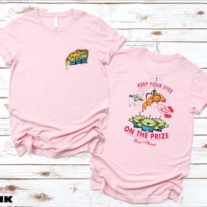 a pink t - shirt with a picture of a cartoon character on it