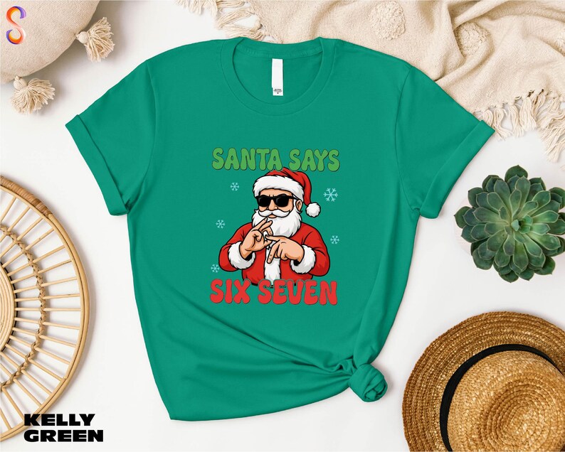 Santa Claus wearing sunglasses and holding up his hand with fingers in front of his face, wearing a green t-shirt with the text "SANTA SAYS SIX SEVEN" printed on it.