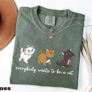 a green t - shirt with three cats on it