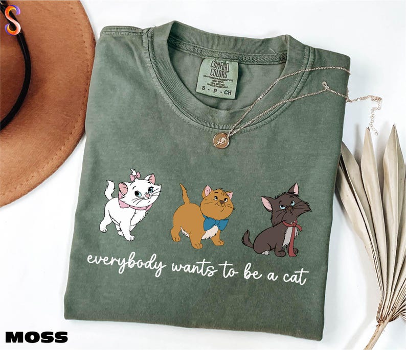 a green t - shirt with three cats on it